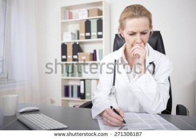 stock-photo-serious-adult-female-medical-doctor-reading-medical-documents-on-the-table-with-one-hand-on-her-271306187